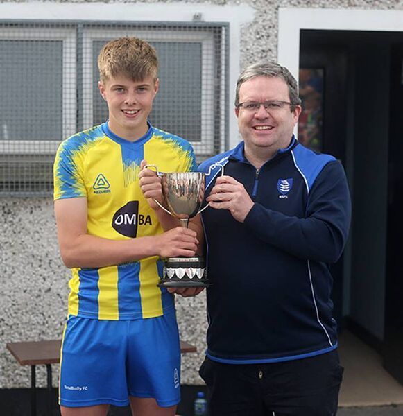 Stradbally captain Aidan Breen receives the WSFL Waterford FC Under 15C Cup from league chairman Davy Cullen.