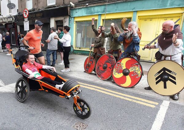 John Butler pictured with his daughter Alex Butler as they pass the Vikings on O'Connell Street heading for the finish line.