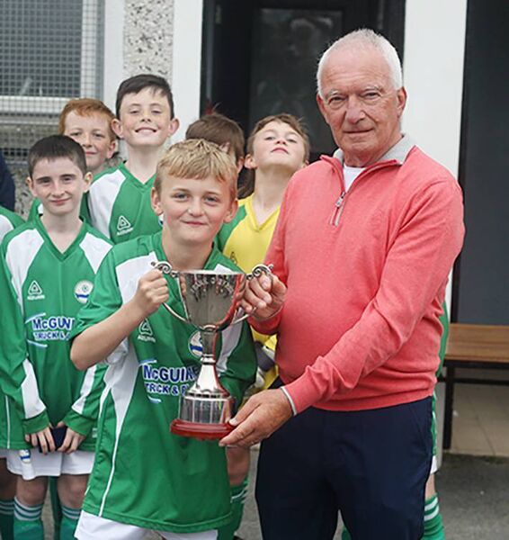 Jack O'Byrne presents the Frank O'Byrne U11E Cup to Ferrybank captain Ben Daly.