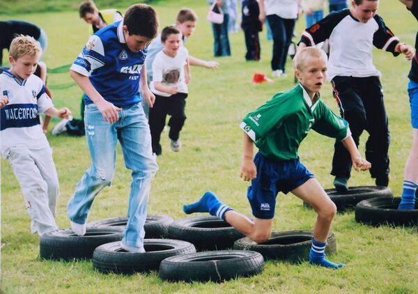 Glen Hawe races through the tyres in the boy's U-12 obstacle race at the 2004 Sacred Heart Parish Field Day.