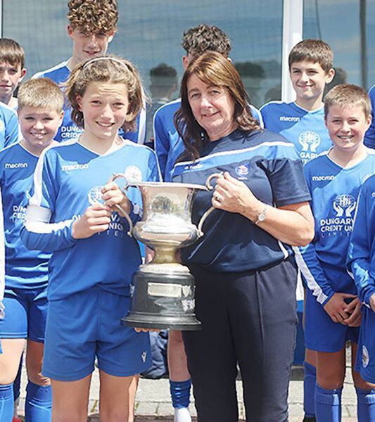 Mary Ray of the WSFL presents Dungarvan United captain James Ferncombe with the Johnny Barnes U13A Cup.