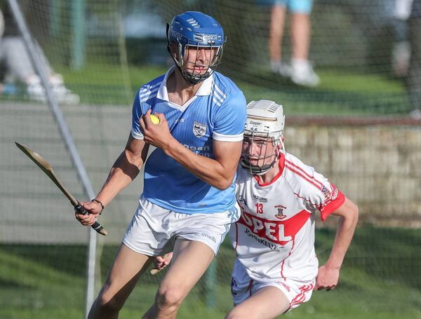 Roanmore's Benjamin Meistas wins possession ahead of De La Salle's Darragh Doyle.