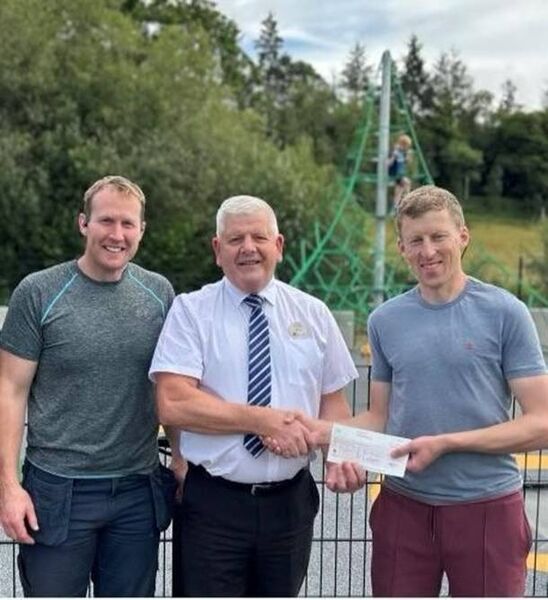 Martin from Tesco, Clonmel, presents a cheque for €800 to members of the volunteer playground committee.