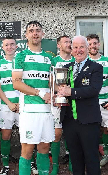 Waterford &amp; District Junior League President John Foskin presents the President's Cup to Villa FC captain Luke Walsh.
