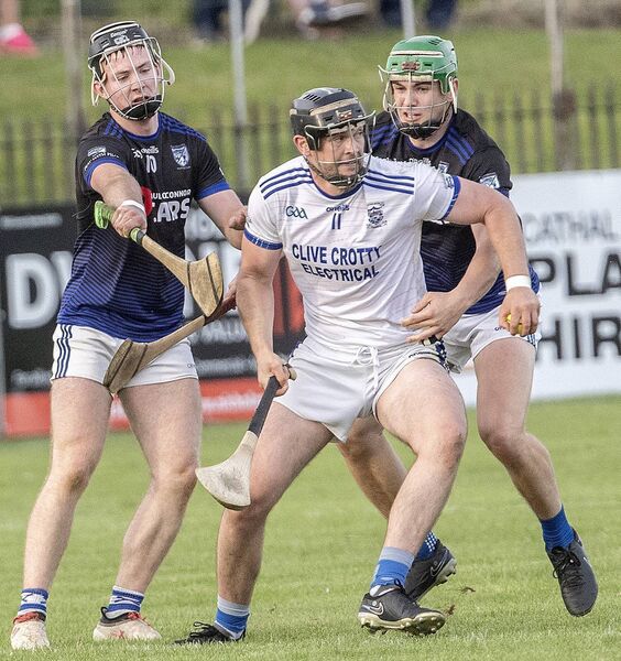 Dungarvan's Colm Curran with the sliothar against Fourmilewater's Michael Morrissey and Tom Barron. 