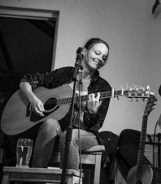 Sarah pictured performing on stage with her guitar