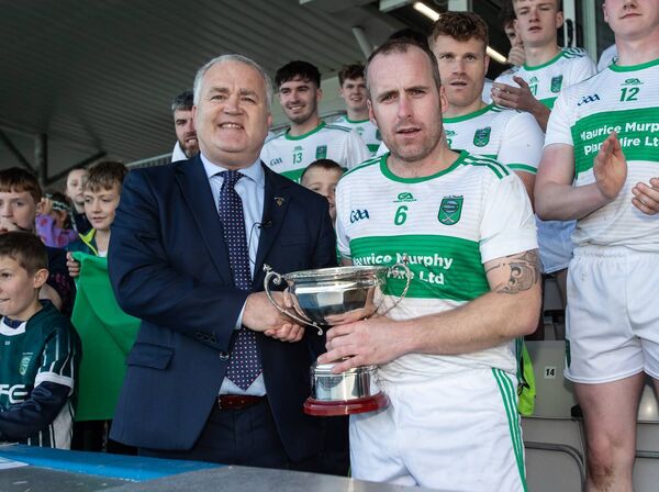 County Board Chairman Sean Michael O'Regan, presents the cup to Fenor captain John Flynn after they defeated Ballyduff Upper in their J.J Kavanagh &amp; Sons County Junior A football final