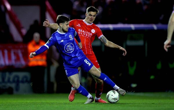 Waterford FC captain Barry Baggley tries to avoid the tackle of Shelbourne's Sean Boyd.