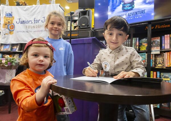 Pictured with Adam as he signs books are Charlie McNicholas and Geoff Cowman. Photograph: Patrick Browne