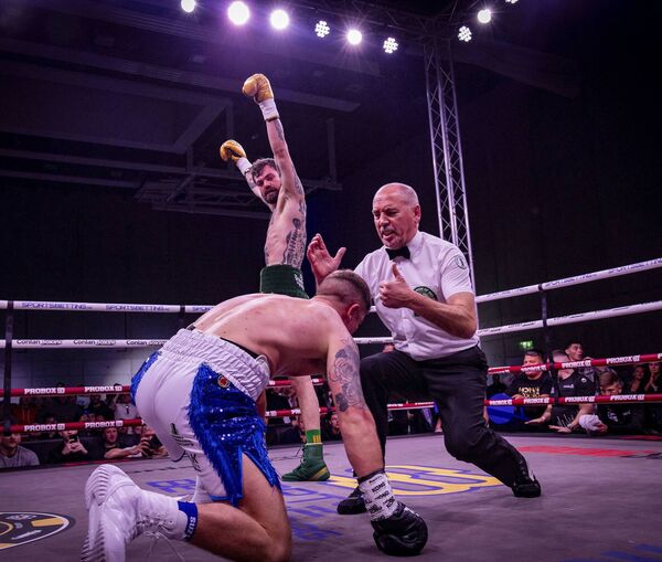 Dylan Moran drops to his knees as Tyrone McKenna celebrates delivering the knockout punch in their War in Waterford boxing event at the SETU Arena. Photos: Joe Evans.
