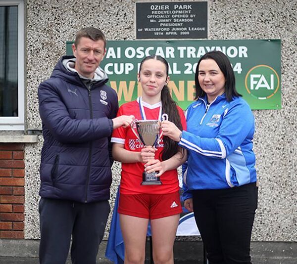 Ballyduff AFC captain Natasha Kearns is presented with the Schoolgirls Under 14C Cup by Waterford FC Women's Coach Gary Hunt and chairperson Janice Lynch at Ozier Park on Sunday last.