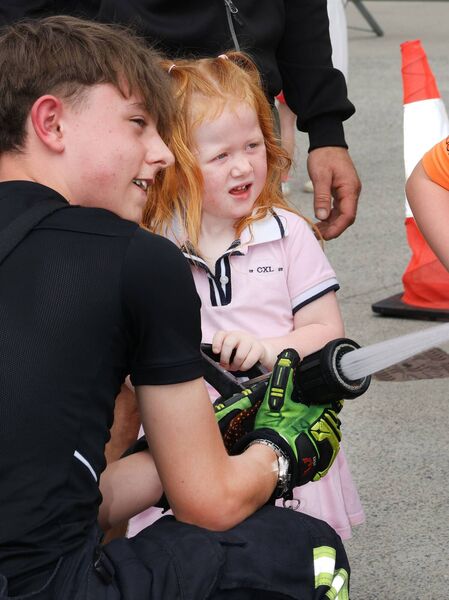 Luke Myler showing Aria how to put out fires at the Waterford Fire Station open day. Photo: Joe Evans