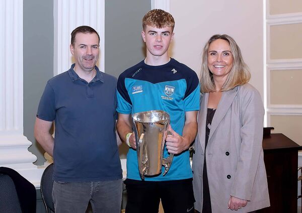 Waterford minor hurling team member Pierce Quann pictured with the Irish Press cup and parents, Aisling and Brian Quann.