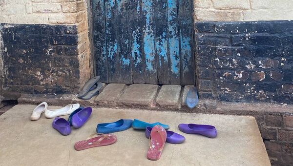 Women and children’s shoes left outside a prison cell in Malawi. Photo courtesy of Prof Marie Claire Van Hout.