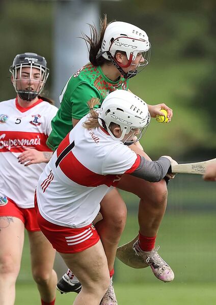 De La Salle goalkeeper Brianna O'Regan takes a strong hit from St Anne's Roisin Kirwan.