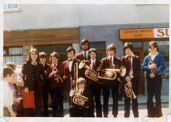 This photo from 1975, in Lismore Park, features Michael Doody (kneeling front centre) when he played with the band for the first time. Michael Quinlan (his teacher) is standing centre back with glasses and beard. Michael was also in attendance at the ceremony This photo from 1975, in Lismore Park, features Michael Doody (kneeling front centre) when he played with the band for the first time. Michael Quinlan (his teacher) is standing centre back with glasses and beard. Michael was also in attendance at the ceremony