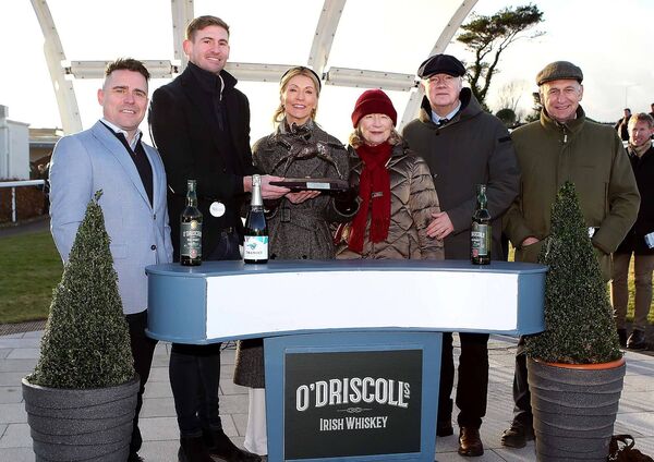 Michael Stafford, CEO and Managing Director, O'Driscoll's Irish Whiskey presents the winners trophy to Carmel Acheson after Heart Wood won the O'Driscoll's Irish Whiskey New Year's Day Chase (Grade 3), also included were Mark Sexton, Sales Director, O'Driscoll's Irish Whiskey, winning trainer Henry de Bromhead and his mother Sally de Bromhead and owner Brian Acheson.