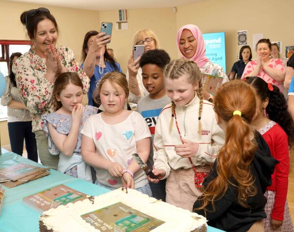 Cutting the cake at Killue Grove to launch, 'Up the hill down the hill', a book about homes and communities by the children of Respond Waterford. Photo: Joe Evans