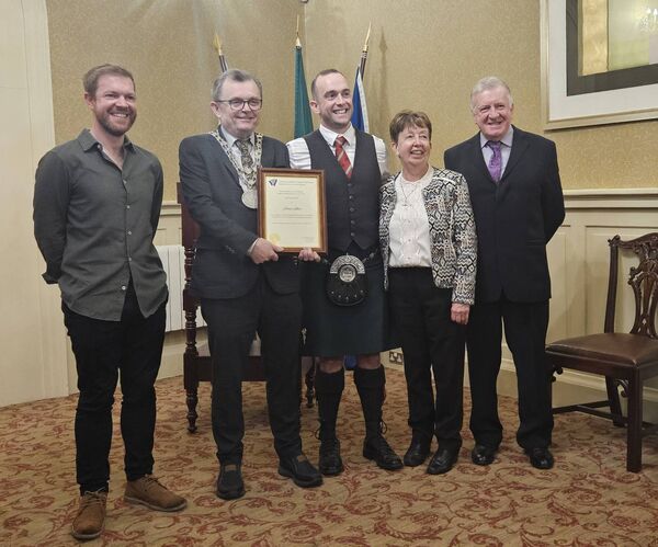 Mayor Ryan presents a scroll to James Stone pictured with his family