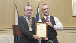 <p>Mayor Ryan presents a scroll to all-Ireland solo pipe champion James Stone at a mayoral reception at City Hall. </p>