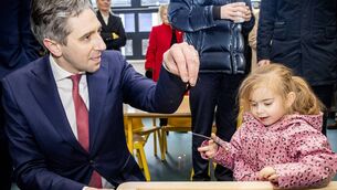 <p>Tánaiste Simon Harris and Harper playing with the rice at St. Ursula's Primary School, for the official opening of the new special class rooms. Photo: Joe Evans</p>