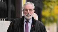 Gerry Adams arrives at High Court for bombings trial