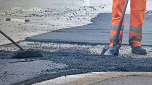 <p>Worker in an orange uniform during a road repair</p> <p>Worker in an orange uniform during a road repair</p>