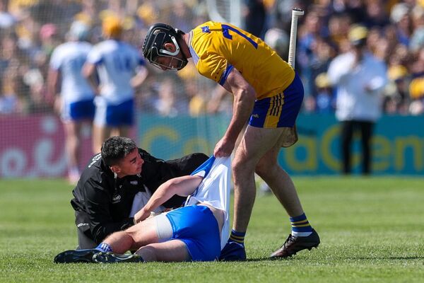 Clare's Cathal Malone pulls up Waterford's Darragh Lyons from the ground.