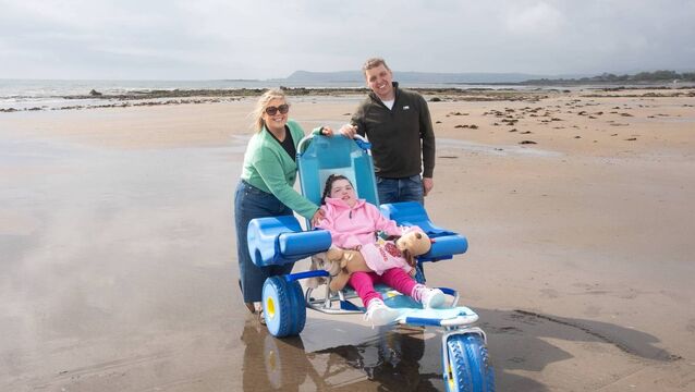 <p>Emily Ahearne with her parents Ann and Liam at the launch of the Clonea Beach Wheelchair Pilot Scheme. Photo: David Clynch</p>