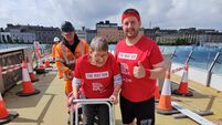 Waterford's Ann Van Hemelendonck and Chris Conroy walk over North Quays bridge for MS funraiser