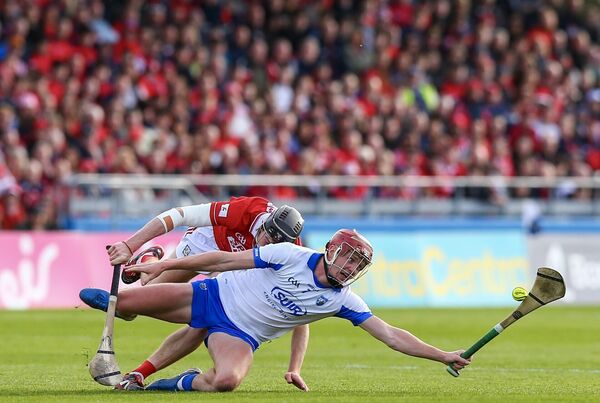 Waterford's Calum Lyons is tackled by Cork's Eoin Downey during their Munster clash. 