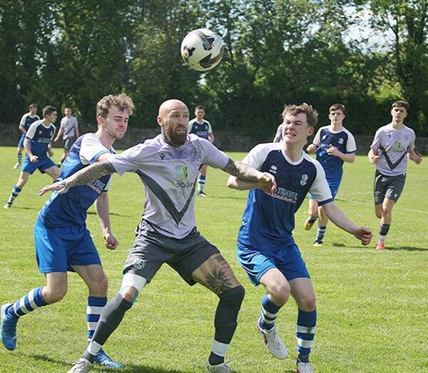 Hibernians Philip Drohan holds off the intentions of two Tulla United defenders during their FAI Junior Cup game.