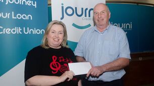 <p>Jean Lacey Chairperson of Waterford High Hopes Choir, accepting a donation from Journi Credit Union, presented by Vincent Flynn. </p>