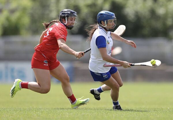 Waterford’s Vikki Falconer takes the ball out of defence ahead of Cork’s Amy O'Connor.