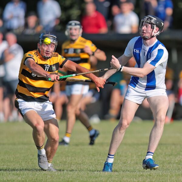 Fourmilewater's Oisin Walsh gets a hand pass away despite the challenge coming in from Lismore's Ben O'Sullivan