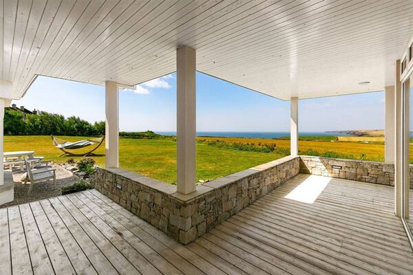 Outside, a sunny sheltered dining terrace and a firepit seating area overlooks the sea Outside, a sunny sheltered dining terrace and a firepit seating area overlooks the sea
