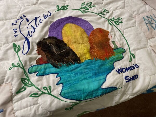 The Three Sisters logo on the quilt, symbolising the unity of the group through nature, art, community and friendship.